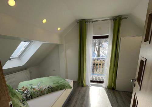 a attic room with a bed and a window at Ferien- und Businesswohnung Sonnentor Dreiländereck im zweiten Stock in Sonnen