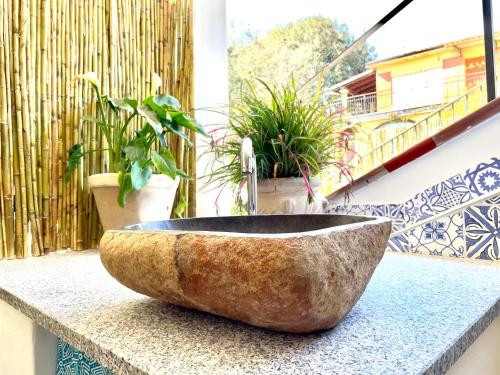 un lavabo de piedra en un balcón con macetas en Le Corti Sarde Countryside, en Bari Sardo