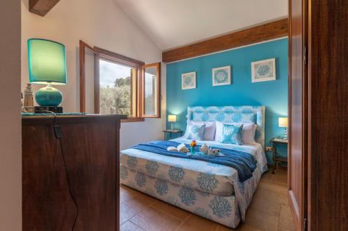 a blue bedroom with a bed and a window at Brassol Casa Vacanze Vista Mare in Alghero