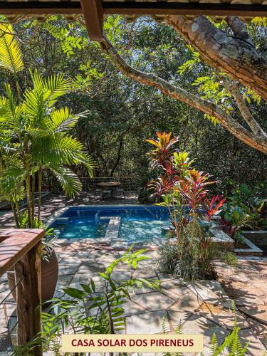 a swimming pool in a garden with trees and plants at Casas Solar dos Pireneus in Pirenópolis