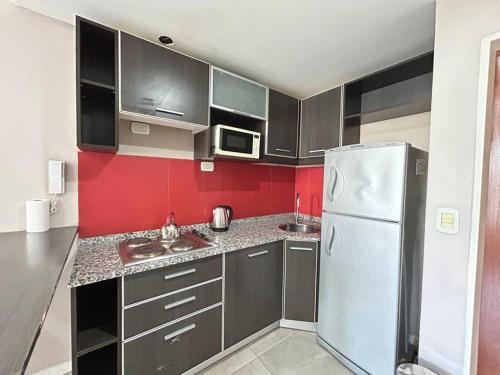 cocina con refrigerador blanca y pared roja en AREN0601 Moderno y cómodo Studio por Barrio Norte en Buenos Aires