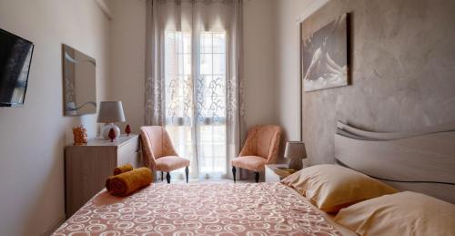 a bedroom with a bed and two chairs and a window at A casa tua Affitti brevi in Noto