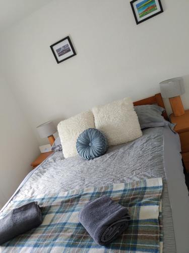 a bedroom with a bed with pillows on it at Cosy 2 Bedroom Croft Cottage with Beautiful Views in North Kessock