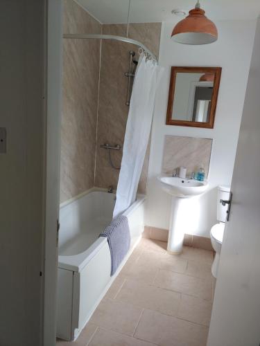 y baño con bañera y lavamanos. en Cosy 2 Bedroom Croft Cottage with Beautiful Views, en North Kessock