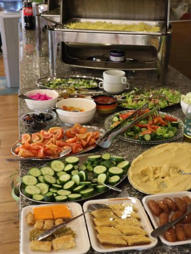 a buffet of different types of food on a counter at Petra cabin Roof top hostel in Wadi Musa