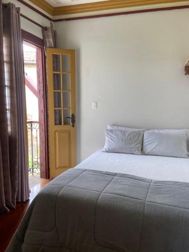 1 dormitorio con cama y puerta amarilla en Casa Nossa Senhora do Carmo en Ouro Preto