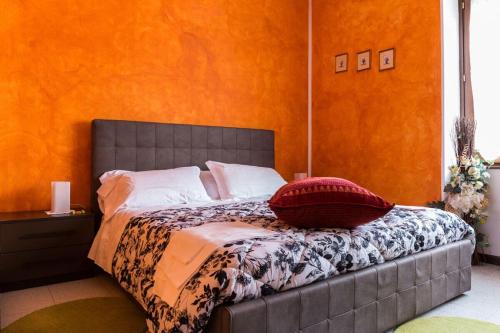 een slaapkamer met een bed met een oranje muur bij Locanda Cà Priula in Albaredo per San Marco