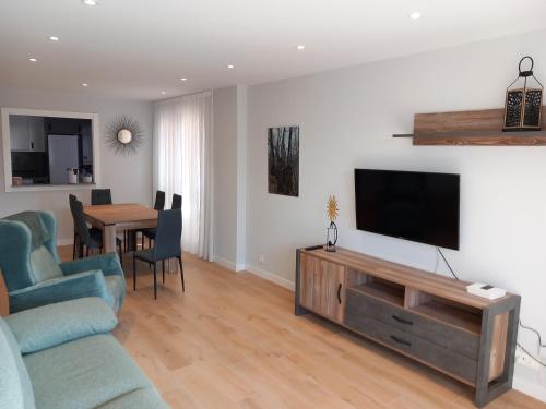 a living room with a couch and a television on a wall at maitzegur etxea in Echarri-Aranaz