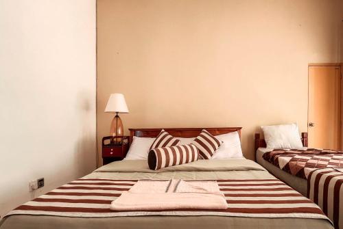 a bedroom with two beds with striped pillows at Hillcrest Haputale in Haputale