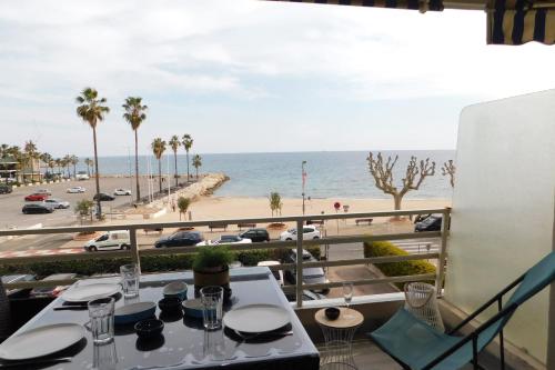 una mesa con vistas a la playa y al océano en T1 Imperial 2 waterfront air conditioning parking, en Vallauris