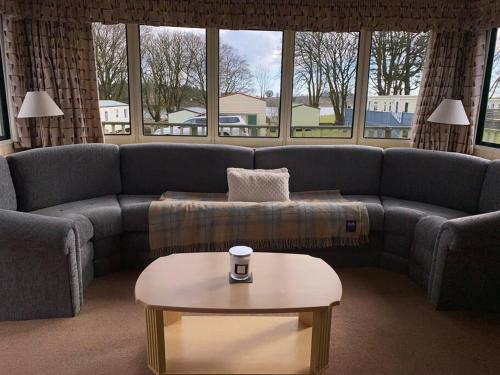 a living room with a couch and a coffee table at No29 at Three Lochs Holiday Park in Balminnoch