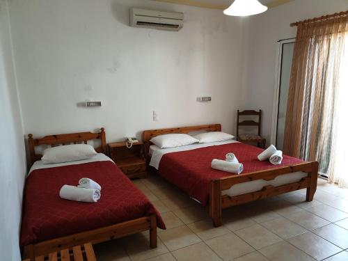 a bedroom with two beds with towels on them at Atlas Pension in Karterados