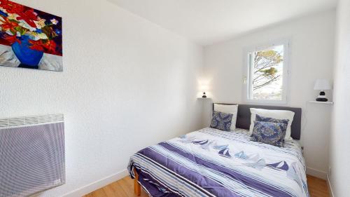 a bedroom with a bed and a painting on the wall at Le Ponton Bleu vue face au Port in Saint-Gilles-Croix-de-Vie
