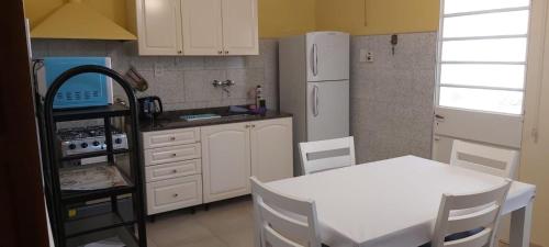 a kitchen with a white table and a white refrigerator at La Casa de Mirna in Formosa