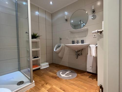 y baño con lavabo y ducha. en MS-Apartments I Ferienhaus Sielterrasse Ditzum, en Ditzum