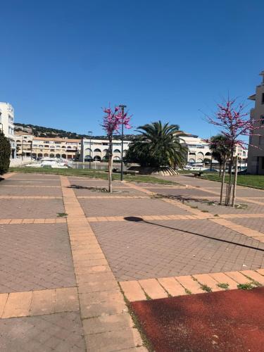 an empty street with trees and buildings in the background at App T2 climatisé , plage 200 m in Sète