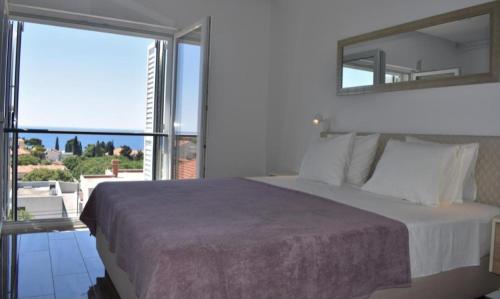 1 dormitorio con cama grande y ventana grande en Apartments Marlin Blue en Dubrovnik