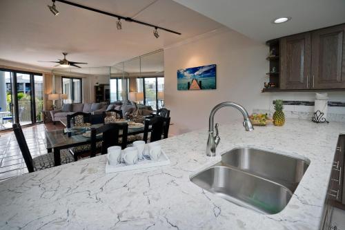 a kitchen with a sink and a living room at Sunrise on the Atlantic in Key West