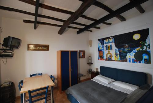 - une chambre avec un lit, une table et une peinture murale dans l'établissement Lipari Studio Old Town, à Lipari