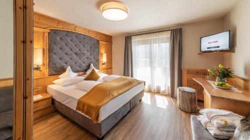 Habitación de hotel con cama grande y TV en Hotel Hirzer ***S, en Saltusio