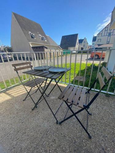 een picknicktafel en een stoel naast een hek bij Appartement bord de mer in Wimereux