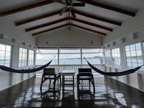 a dining room with a hammock and a table and chairs at Barrbra BnB Over The Sea in Bocas Town