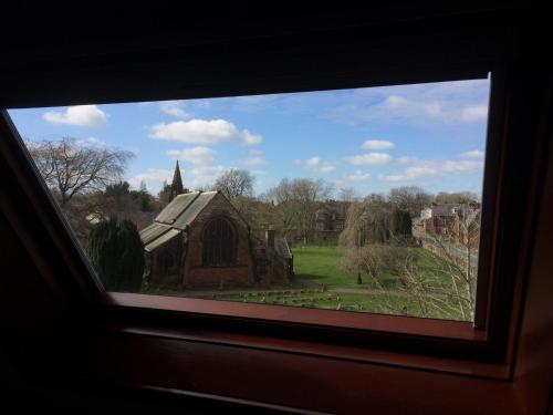 a view of a church through a window at Stylish Apartment in Stone-Built Former Rectory in Penrith