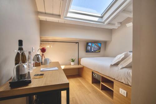 een slaapkamer met een bed, een bureau en een raam bij Archè Design Rooms and Suites in Palermo