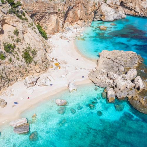 an aerial view of a beach with rocks and blue water at Le Corti Sarde Countryside in Bari Sardo