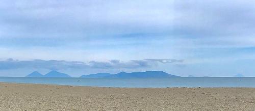 a beach with mountains in the distance and the ocean at Margherita sul mare - 250 m from the beach in San Giorgio