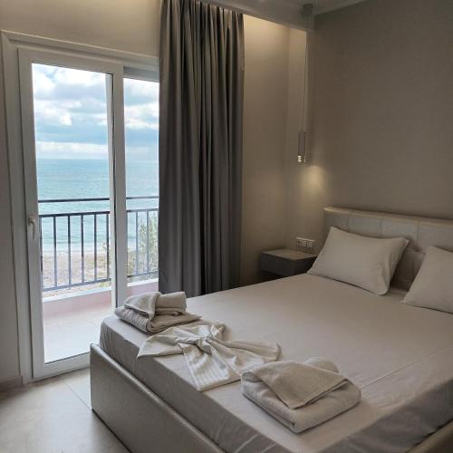 a bedroom with a bed with a view of the ocean at Golfo Beach in Parga