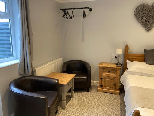 a bedroom with two chairs and a desk and a bed at Wicks at 26 in Sandown