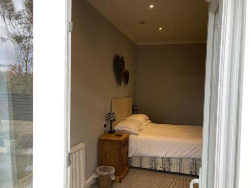 a bedroom with a bed with white sheets and a window at Wicks at 26 in Sandown