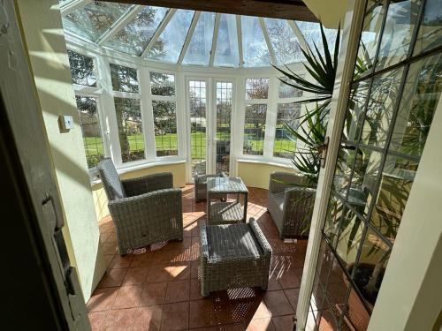an empty conservatory with chairs and a table and a glass roof at Valesmoor Farm in New Milton