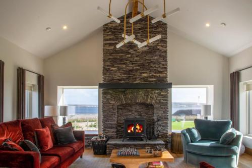 a living room with a fireplace and a red couch at Sruthan Pier House in Carraroe