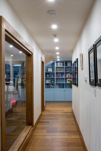 a hallway with a door leading to a room with books at Sruthan Pier House in Carraroe