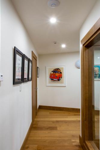 a hallway with white walls and wooden floors at Sruthan Pier House in Carraroe