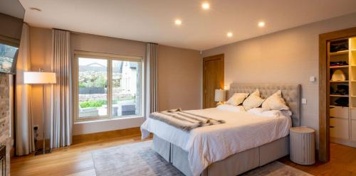 a bedroom with a large bed and a large window at Sruthan Pier House in Carraroe