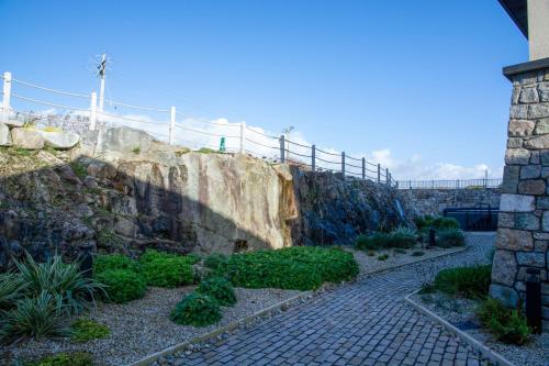 a stone wall with a fence on top of it at Sruthan Pier House in Carraroe