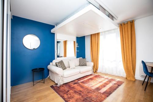 a living room with blue walls and a white couch at Experience olympique proche Paris in Le Plessis-Robinson