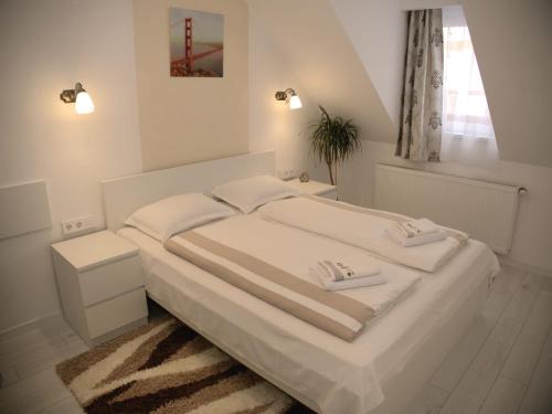 una camera da letto bianca con un letto e una finestra di Casa Todor a Sibiu