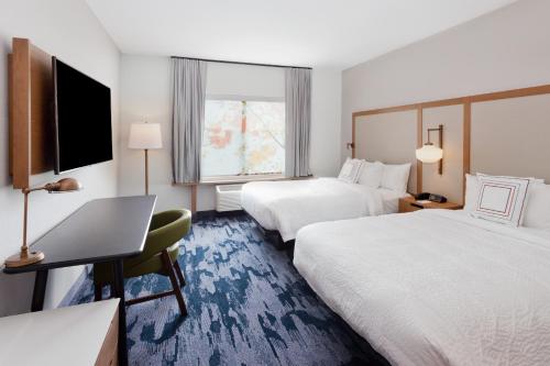 a hotel room with two beds and a desk with a laptop at Fairfield Inn & Suites by Marriott Birmingham Colonnade in Birmingham