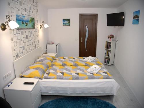 シビウにあるPensiunea Todorのベッドルーム1室(黄色と灰色の掛け布団付きのベッド1台付)