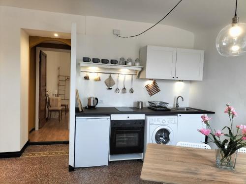 La cuisine est équipée de placards blancs et d'un lave-vaisselle. dans l'établissement La casa di Fabi, à Arcola