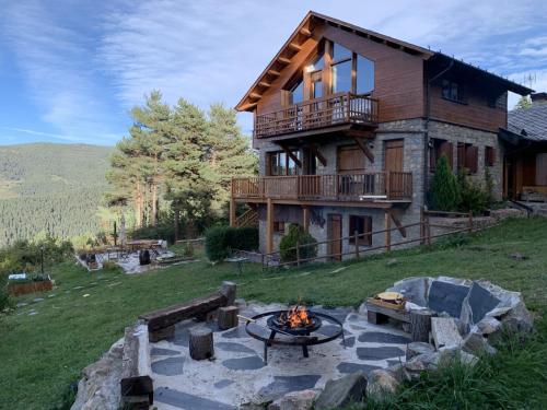 a house with a fire pit in front of it at Minds & Mountains Eco Lodge in La Molina