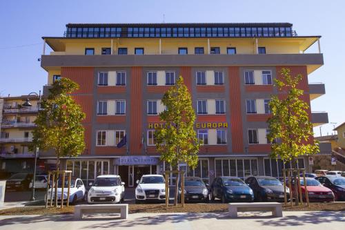 a building with cars parked in a parking lot at Hotel Europa in Signa