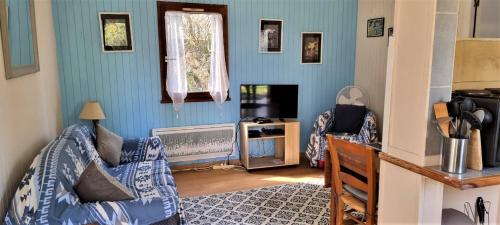 a living room with a couch and a television at Weir Cottage in Balledent