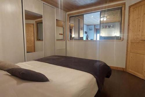 una camera da letto con un grande letto e una finestra di Les Hauts de Sallanches a Sallanches