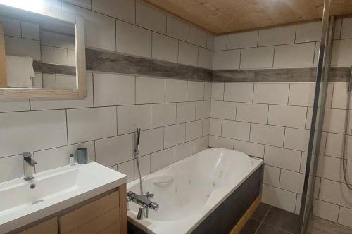 a bathroom with a bath tub and a sink at Les Hauts de Sallanches in Sallanches