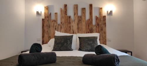 een slaapkamer met een bed met een groot houten hoofdeinde bij Gîte - Les Pivoines Les Jardins de Kerellec 20min de la mer 4 à 6 personnes terrasse in Plouvorn